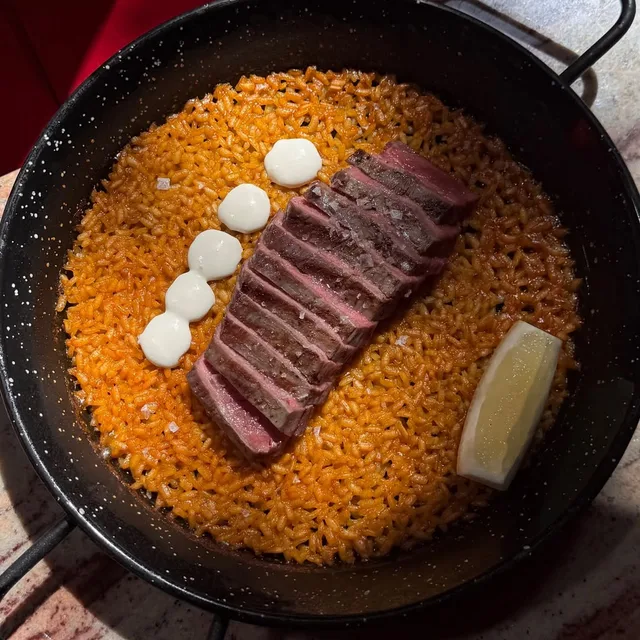 Rice and sliced steak in a pan at Pablo’s Tapas