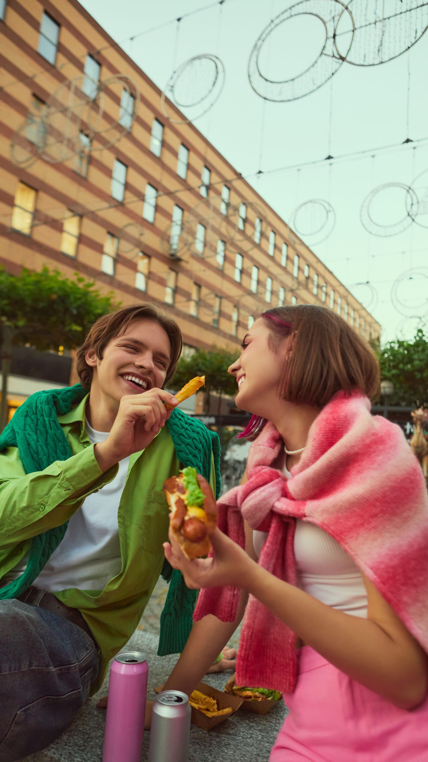 Two people laughing over a meal outside